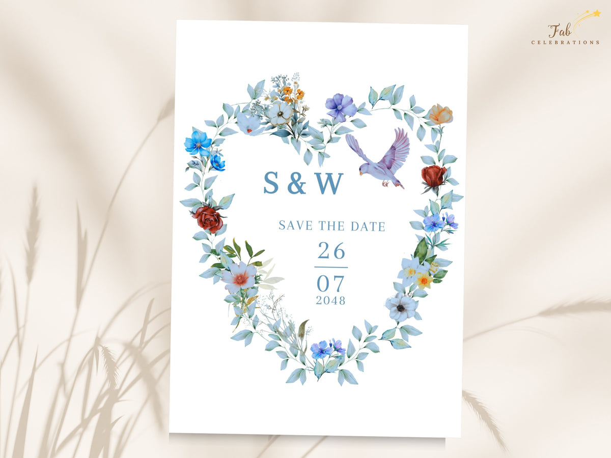 Blue and Green Save the Date Card featuring a watercolor-inspired heart-shaped wreath with blue flowers, green foliage and two graceful doves framing the couple's initials and wedding date.