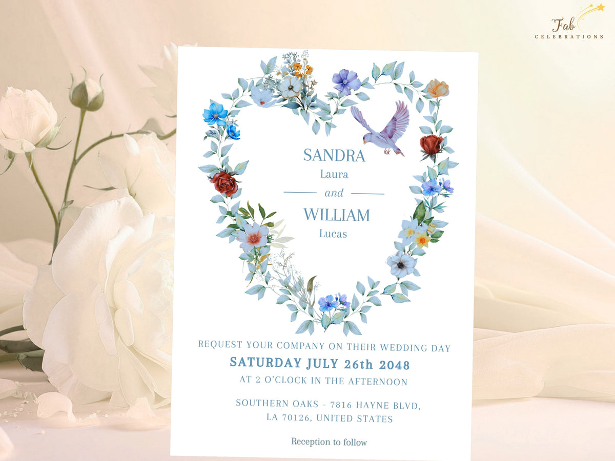 Elegant wedding invitation front with a watercolor-inspired heart-shaped floral wreath, soft blue and ivory blooms, airy greenery and two doves framing the couple's names and wedding information.