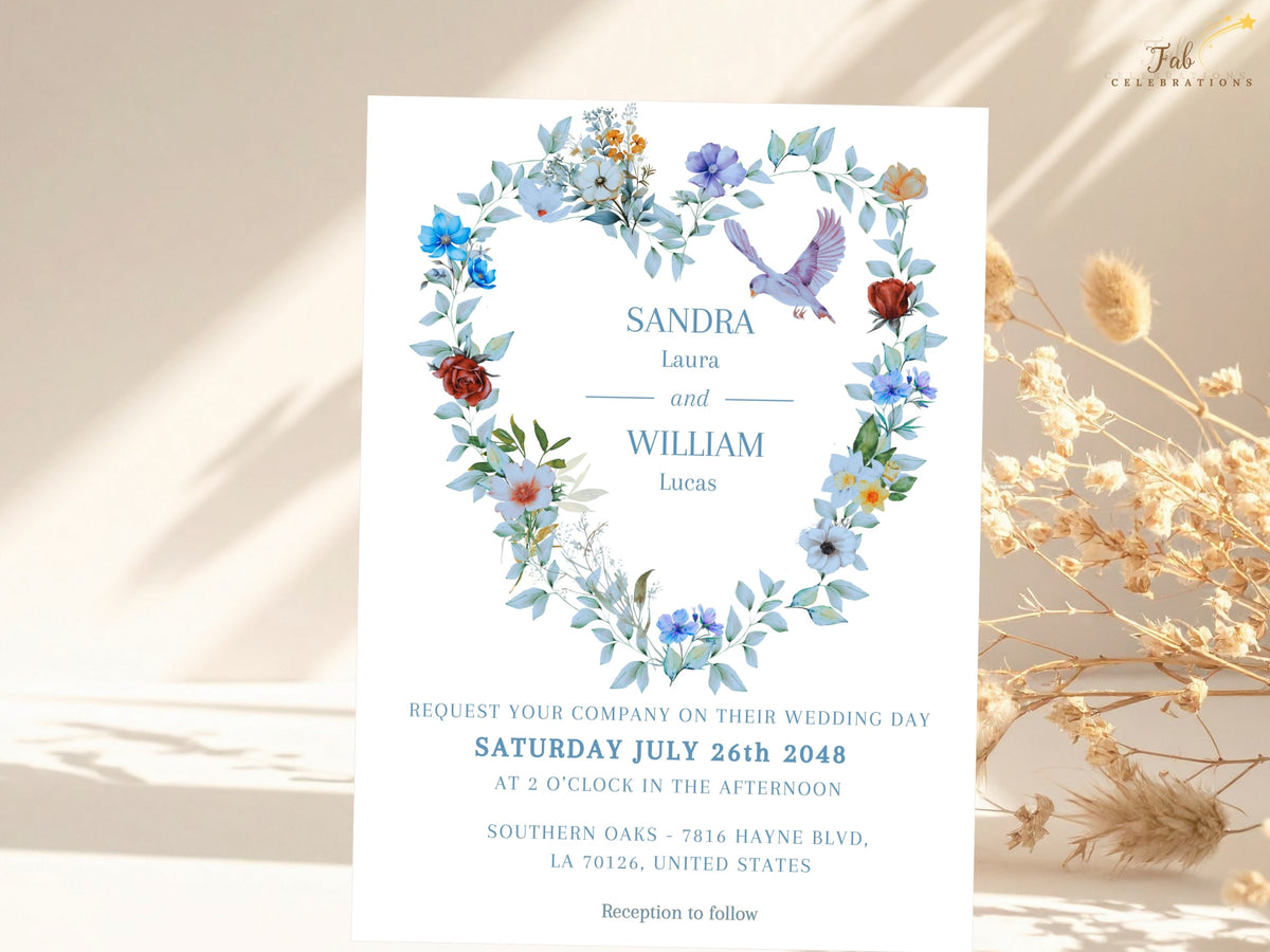 Wedding invitation front featuring a watercolor-inspired floral heart wreath with soft blue flowers, greenery and two doves surrounding elegant blue typography for a romantic coordinated celebration.
