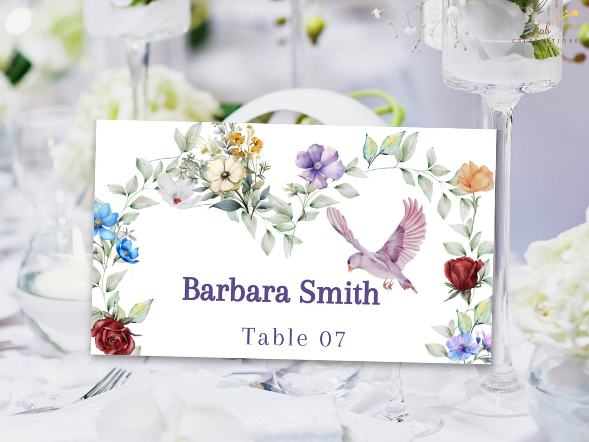 Garden wedding place card featuring watercolor-inspired multicolored blossoms, leafy greenery and a graceful dove surrounding the guest name Barbara Smith and reception table number 07.