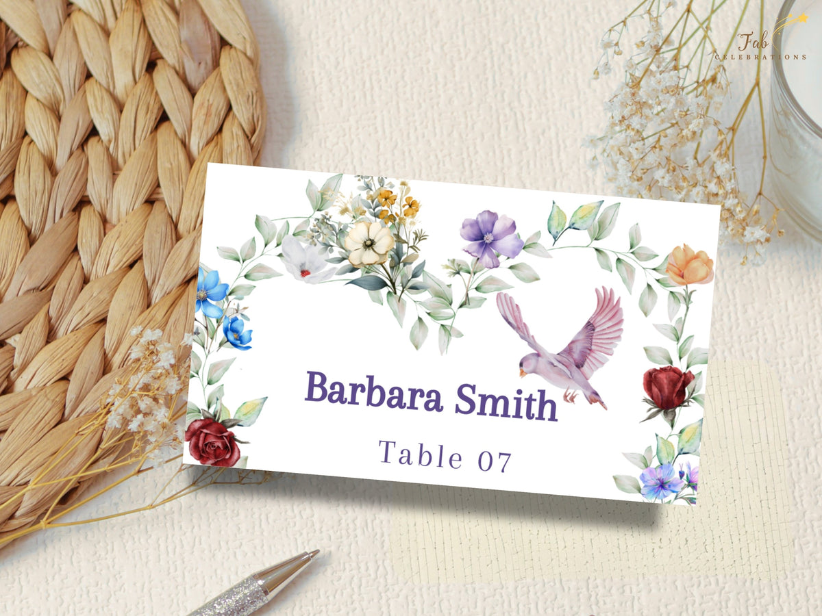 Reception name card featuring watercolor-inspired colorful flowers, delicate greenery and a graceful dove framing the guest name Barbara Smith with the assigned table number 07.