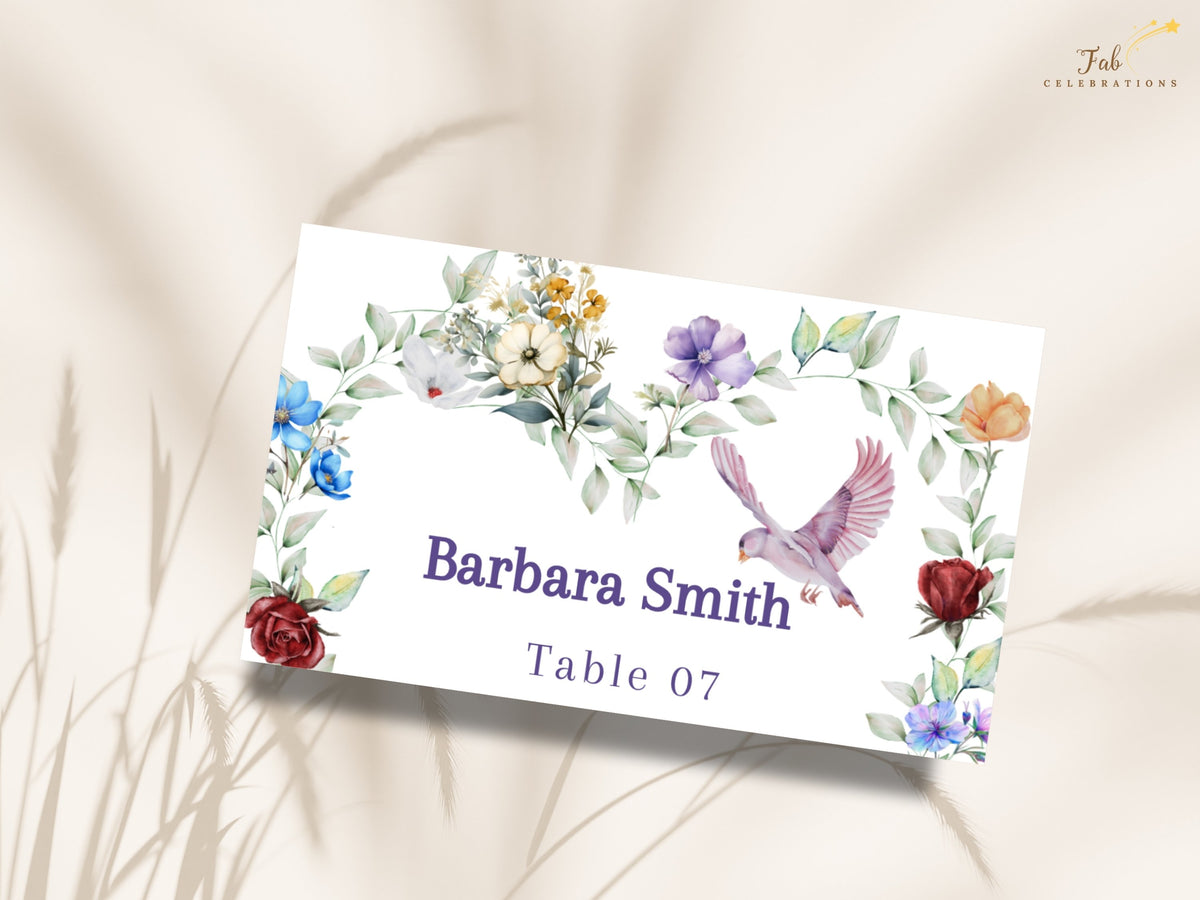 Watercolor-inspired wedding place card featuring colorful garden blossoms, soft leafy greenery and a graceful dove around the guest name Barbara Smith and reception table number 07.