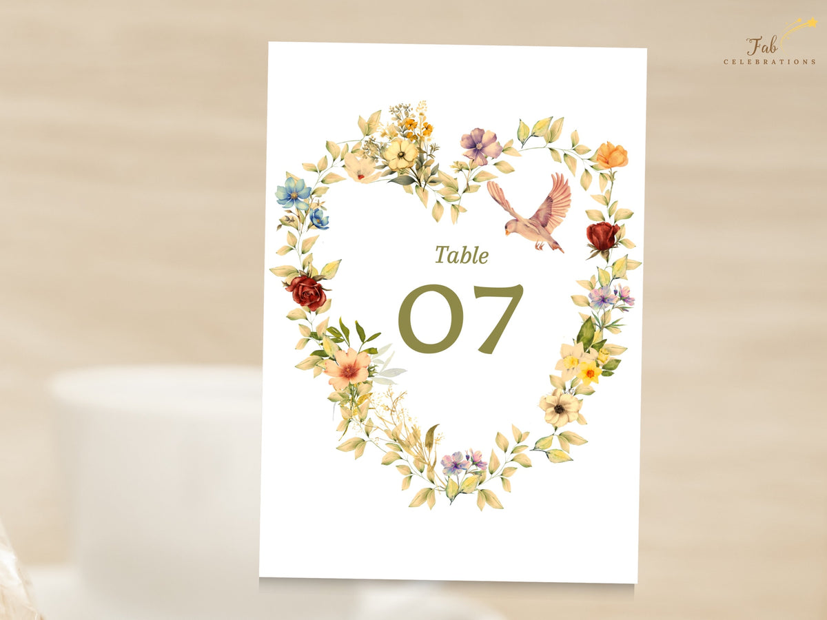 Editable floral dove wedding table number with a watercolor-inspired heart of golden blossoms, soft pink flowers, and sage greenery surrounding an elegant table 07 for reception seating.