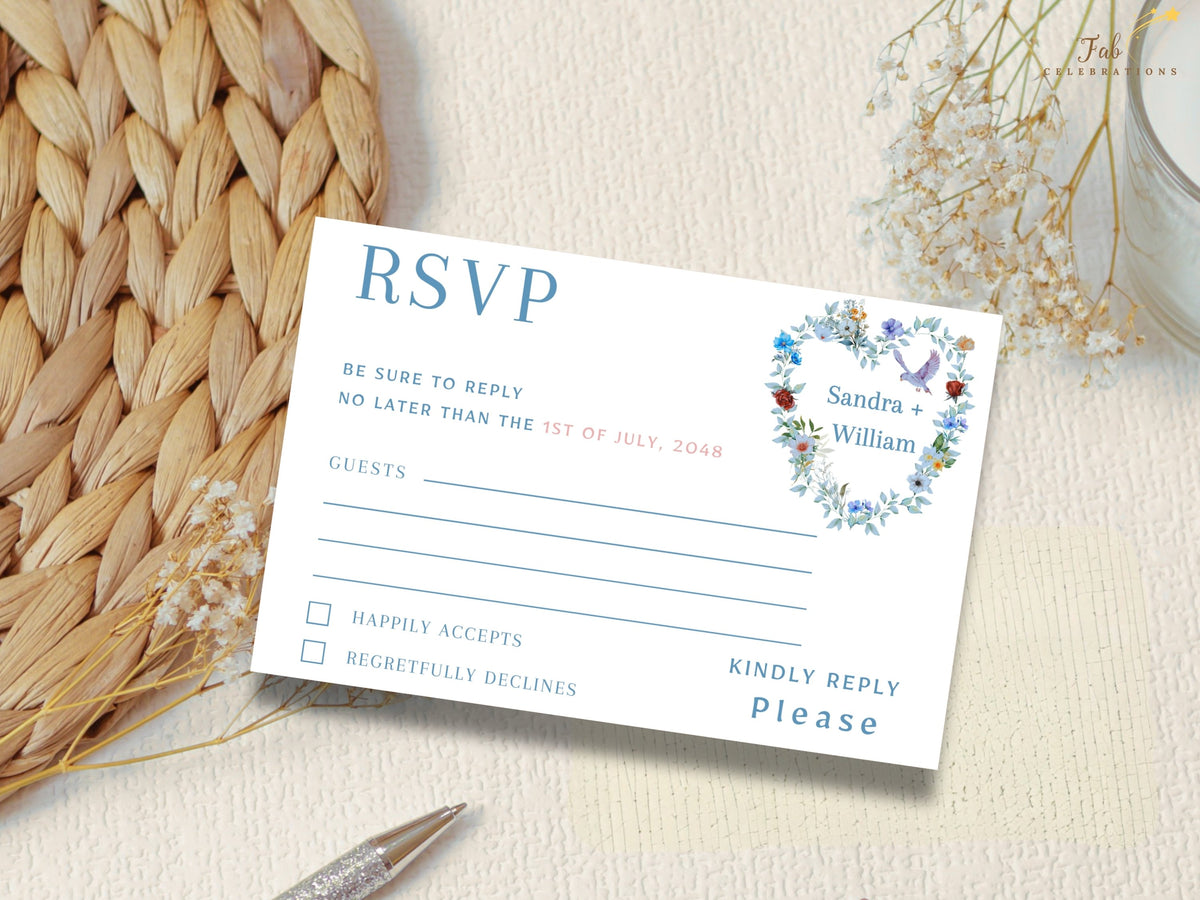 Wedding RSVP card featuring a watercolor-inspired floral heart arrangement with soft blue flowers, greenery and two doves above elegant response fields for guest names and attendance selections.