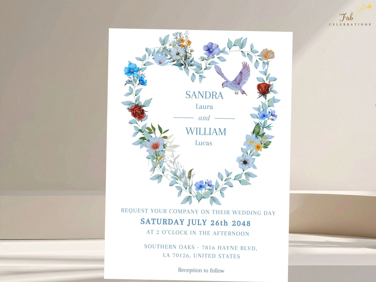 Wedding invitation template featuring a watercolor-inspired floral heart wreath with dusty blue flowers, greenery and two graceful doves framing refined typography and ceremony details.