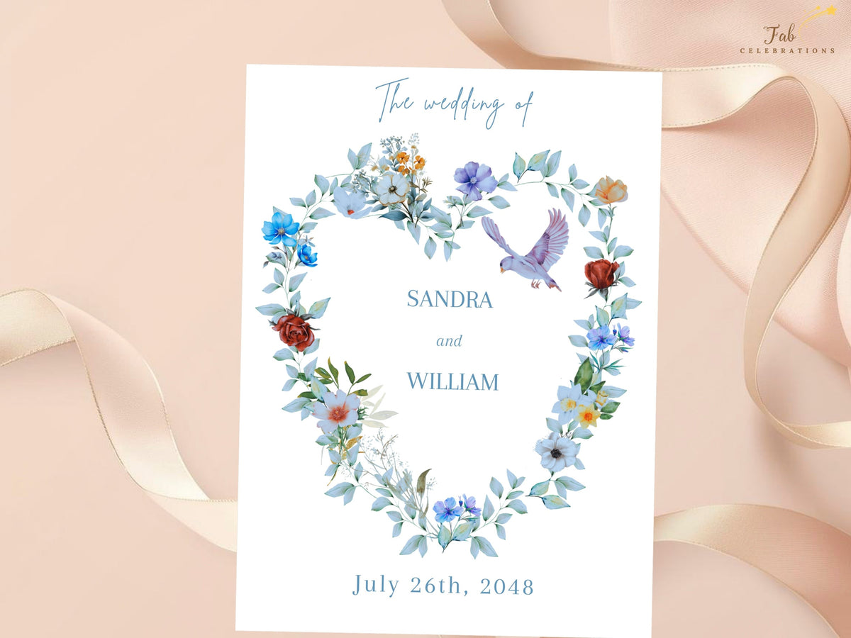 Wedding invitation front with a watercolor-inspired heart wreath of dusty blue blooms, soft greenery and two graceful doves framing the couple names and ceremony details in refined typography.