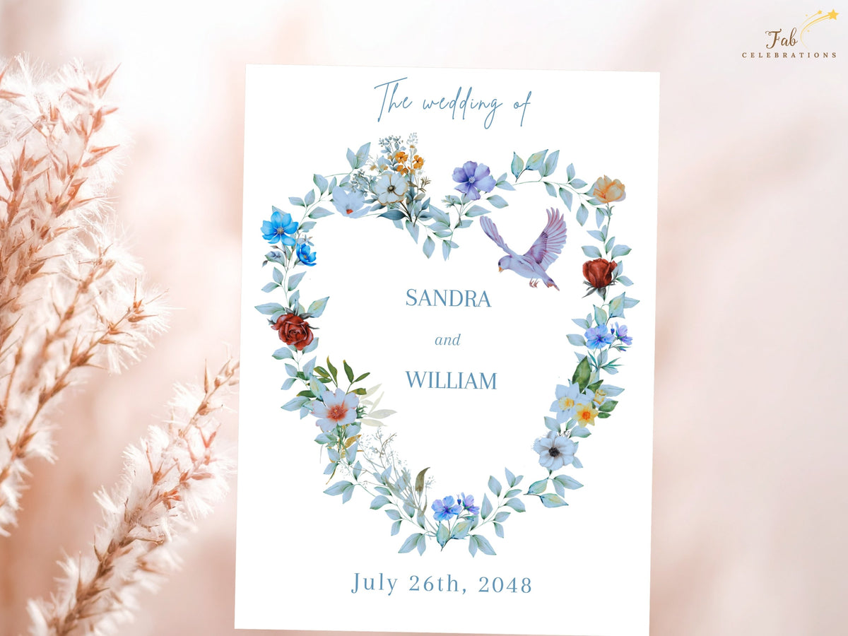 Wedding invitation text back featuring a watercolor-inspired floral wreath with dusty blue blooms, greenery and two doves surrounding the couple names and wedding date in coordinated typography.