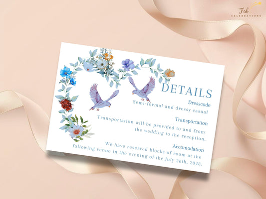 Elegant Wedding Details Card featuring watercolor-inspired blue and ivory flowers with two graceful doves above organized sections for dress code, transportation, accommodations and wedding website information.