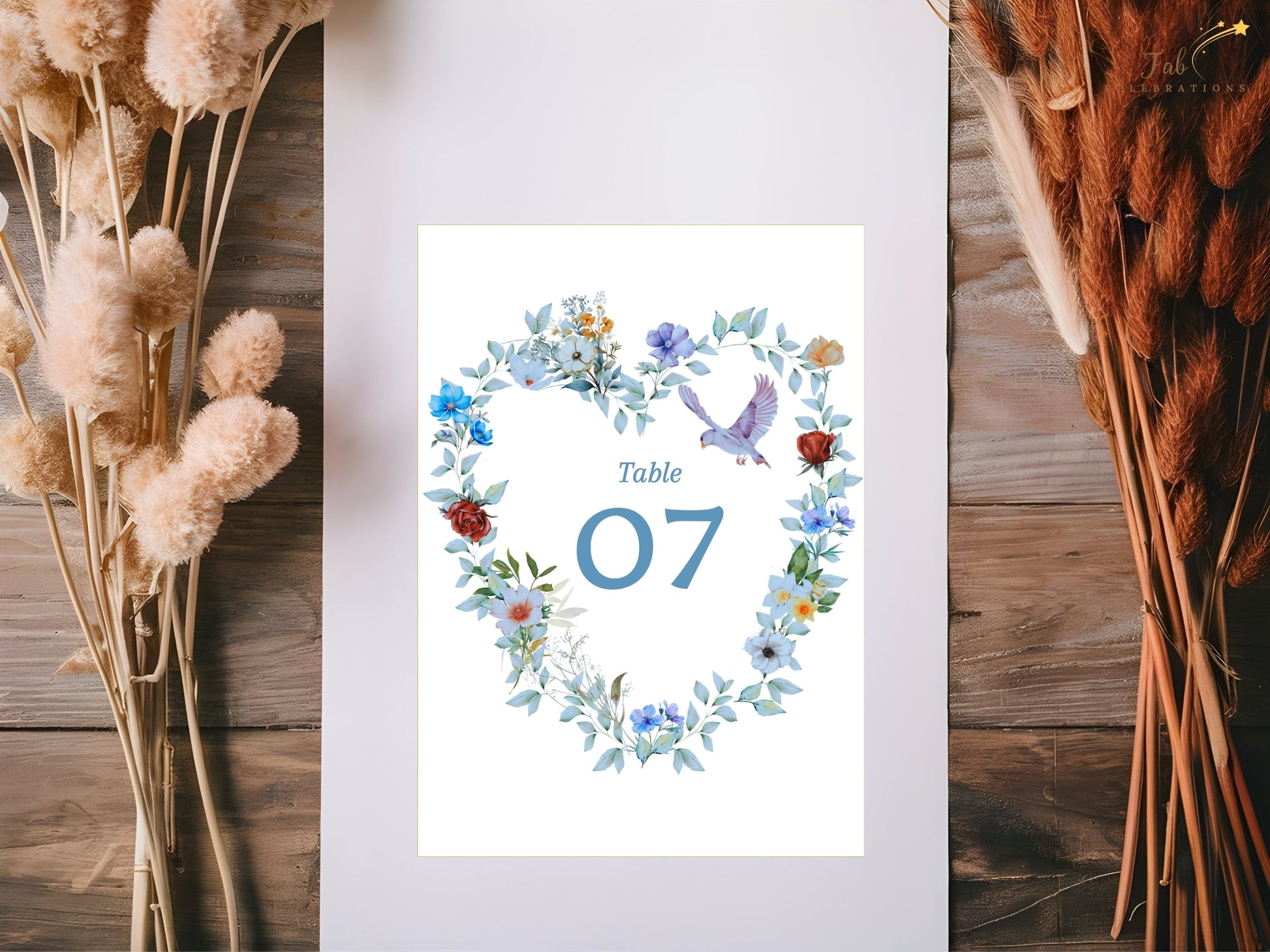 Romantic table number template featuring a blue floral heart wreath, graceful dove motif and elegant typography for beautifully coordinated wedding reception décor.