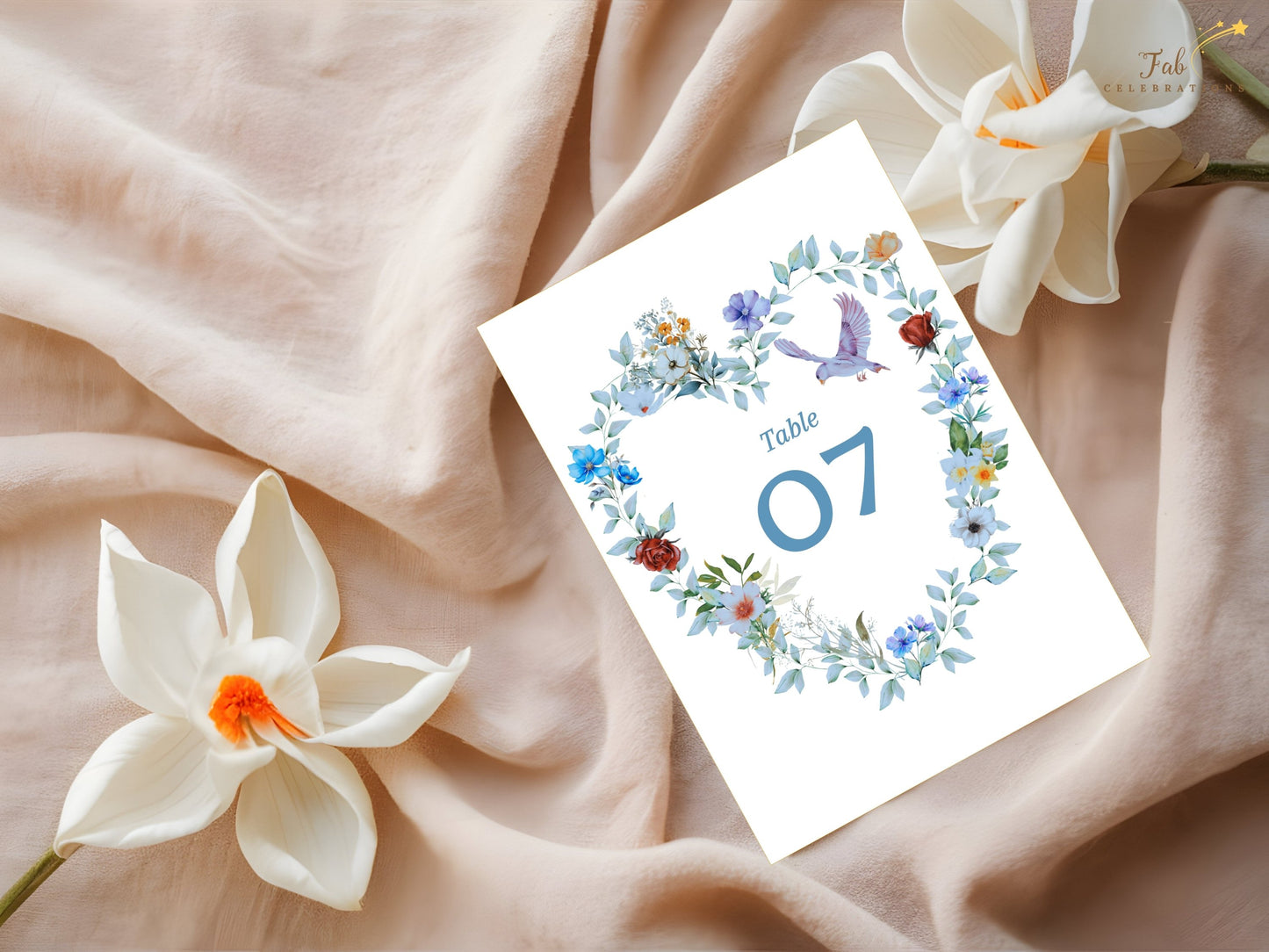 Watercolor-inspired wedding table number card featuring blue floral details, a symbolic dove and romantic artwork that complements a coordinated wedding suite.