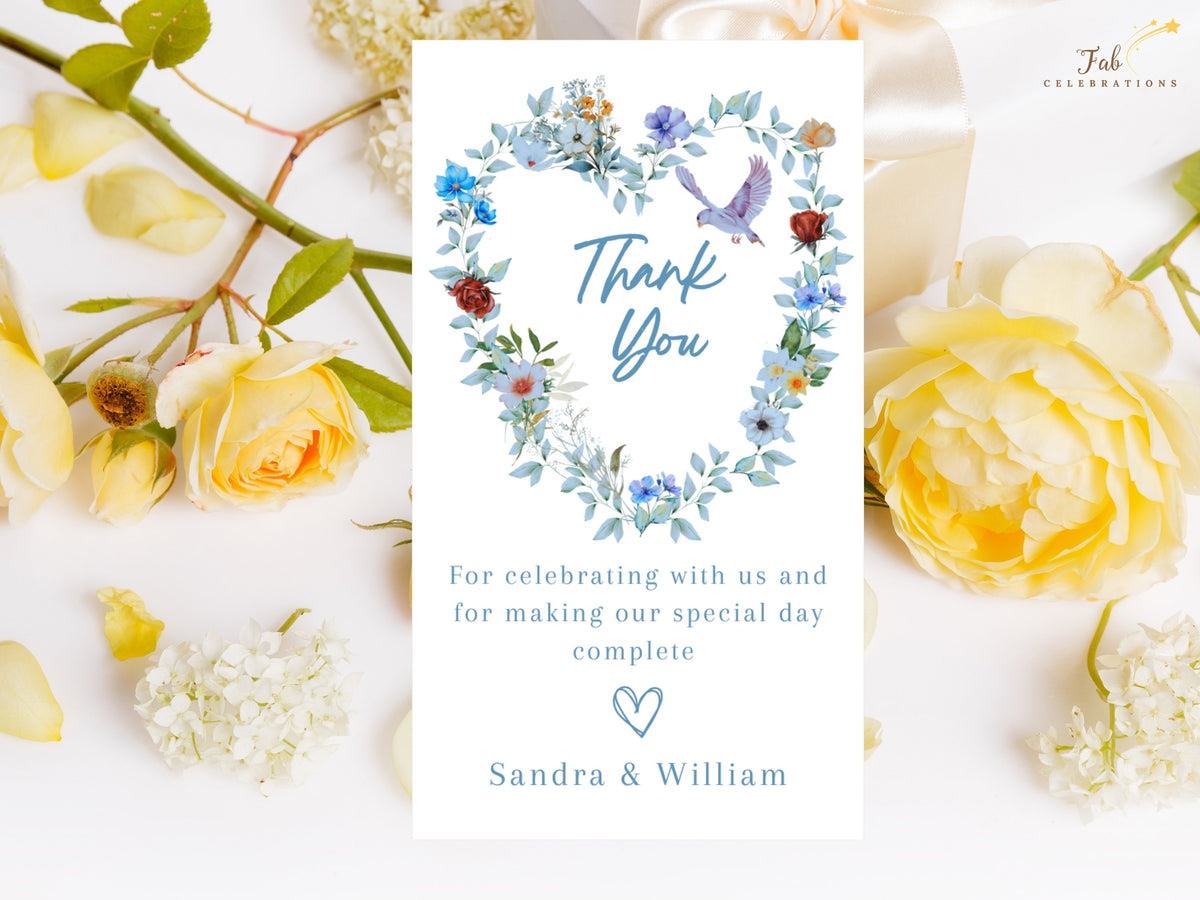 Elegant Wedding Thank You Card featuring a watercolor-inspired heart-shaped wreath with blue flowers, green foliage, delicate butterflies and a graceful dove surrounding a handwritten-style Thank You message.