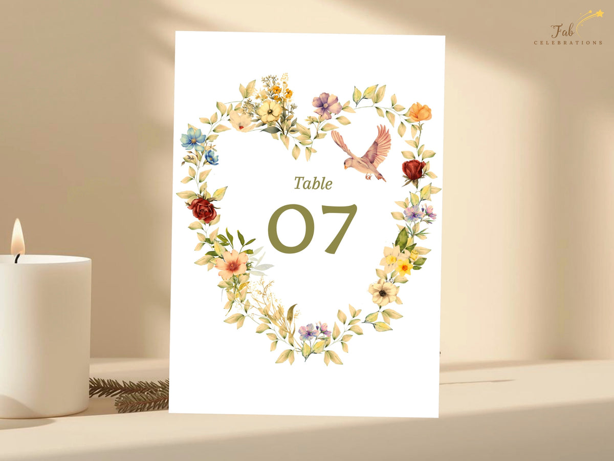 Romantic table number template with golden floral accents, blush blossoms, delicate doves, and a watercolor-inspired botanical heart framing an editable olive green table number 07.