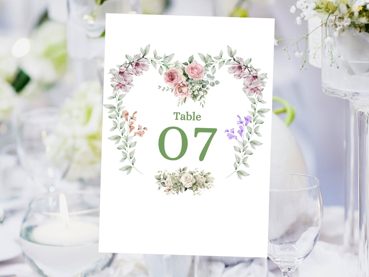 Editable wedding table number card featuring Table 07 with a watercolor-inspired floral heart arrangement, soft pink flowers, purple accents and delicate green foliage.