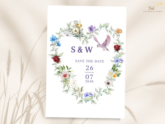 French Countryside Wedding save the date card featuring a watercolor-inspired floral heart with colorful blossoms, soft greenery and a graceful dove surrounding the couple's initials and wedding date.