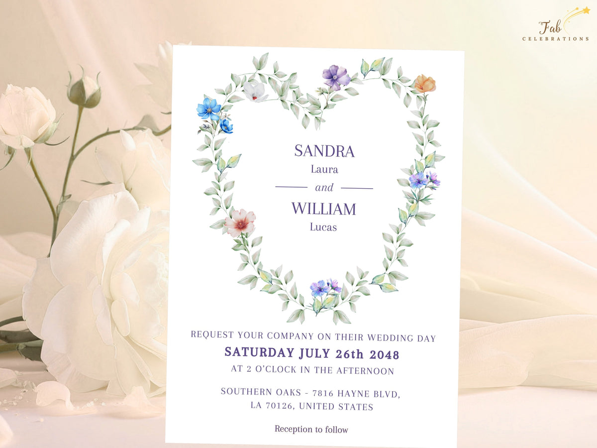 Heart Shaped Wedding Invitation Set invitation front with a romantic watercolor-inspired heart wreath of airy green leaves and delicate blue, purple, white and peach flowers surrounding elegant purple wedding text.