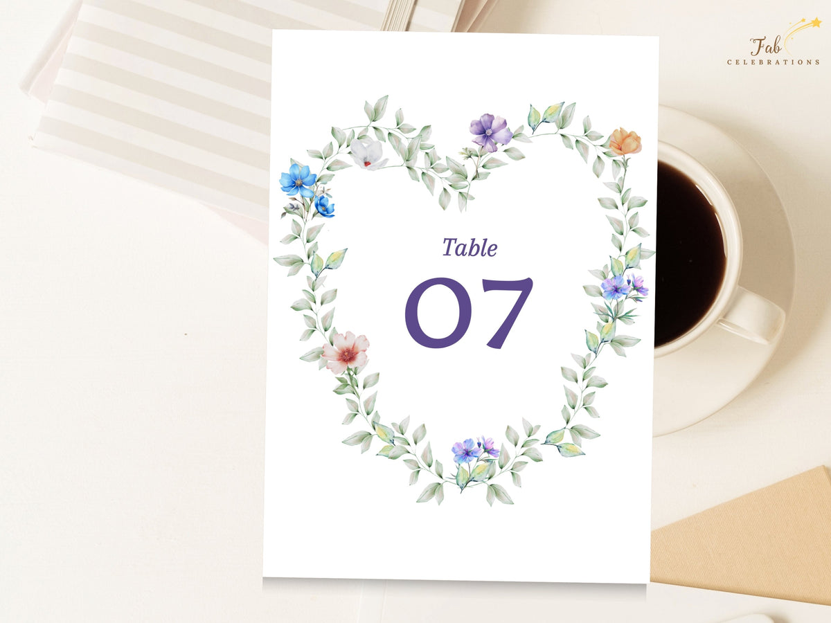 Pastel Garden Table Number featuring a large elegant purple table number framed by a watercolor-inspired wreath of airy green foliage and delicate blue, purple, white, peach and pink flowers.
