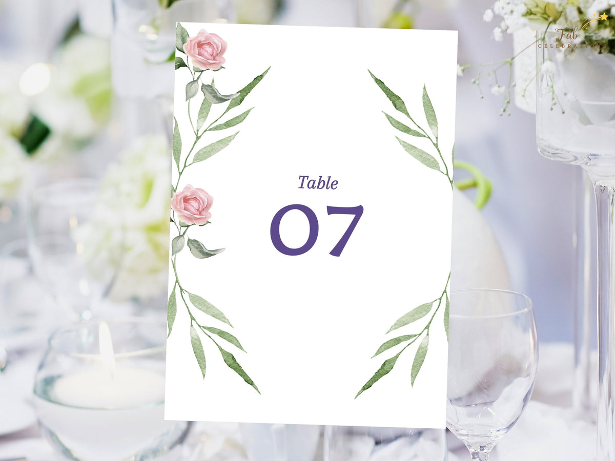 Botanical wedding table number card featuring watercolor-inspired pink roses and long green leafy branches surrounding a clear purple number for coordinated reception table identification.