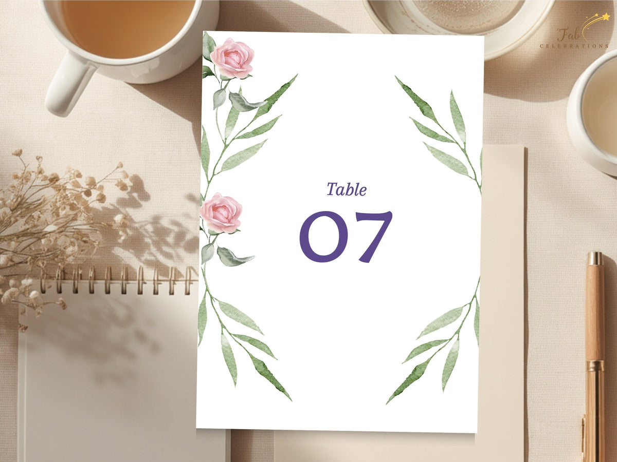 Elegant wedding table number card featuring watercolor-inspired pink roses and sweeping green leaves framing a large purple number for a romantic floral reception table display.