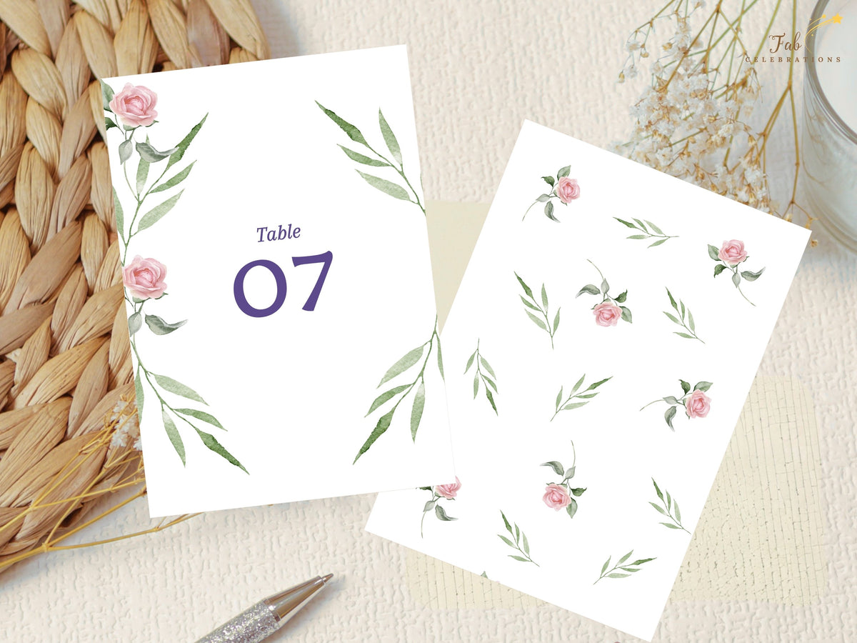 Pink Rose Wedding Table Number Card displayed beside the watercolor-inspired pink rose and green foliage elements used to create the coordinated botanical design throughout the collection.