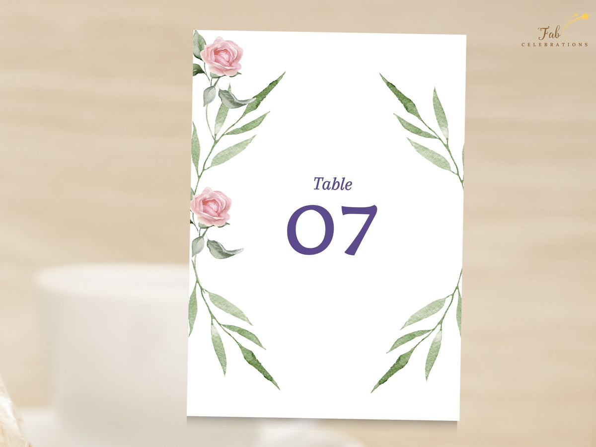 Wedding table number card decorated with watercolor-inspired pink roses and slender green botanical accents, highlighting a large purple table number in a refined floral composition.