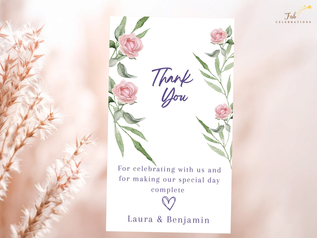 Romantic wedding thank you card decorated with watercolor-inspired blush roses and leafy green accents, combining elegant purple lettering with a warm gratitude message and couple names.