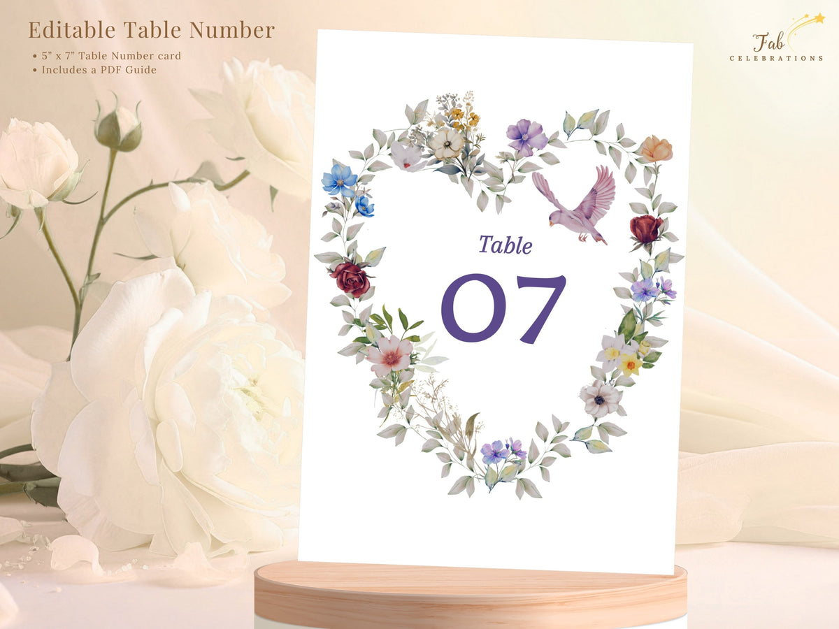 Editable wedding table number seven displayed with a watercolor-inspired floral heart, soft botanical leaves and a graceful dove, designed for coordinated reception tables. Editable in Canva.