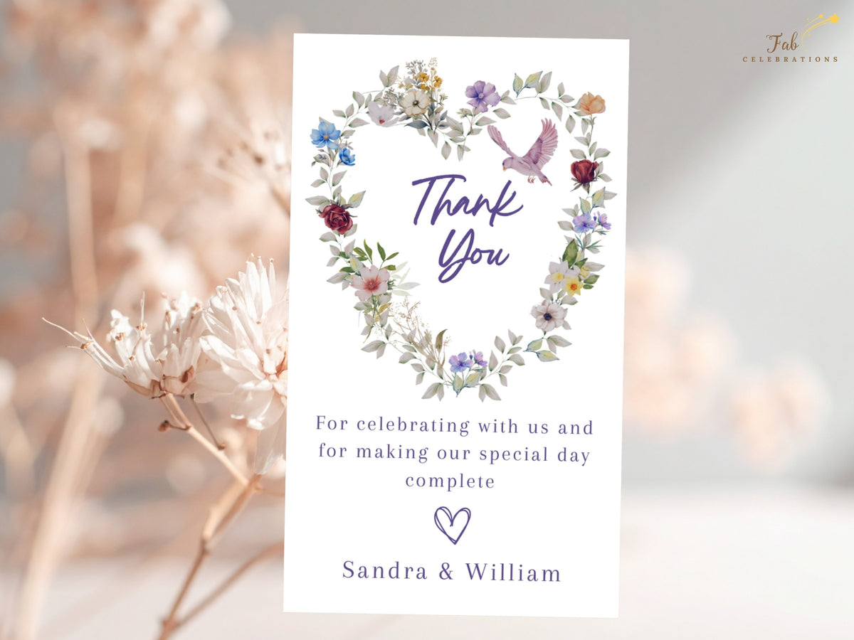 Heartfelt wedding thank you card displaying watercolor-inspired flowers in blue, violet and rose around a graceful dove, with customizable gratitude wording and the couple's names at the bottom.