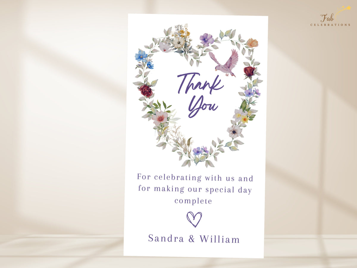 Printable thank you card with flowing purple script, watercolor-inspired blue and violet flowers, soft pink blossoms and a small dove, with an editable message and signature for wedding guests.