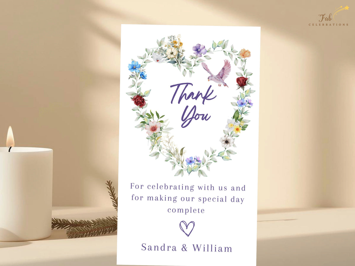 Elegant gratitude card featuring a watercolor-inspired floral heart, colorful garden blossoms and soft greenery with a graceful dove above a warm thank you message and couple's names.