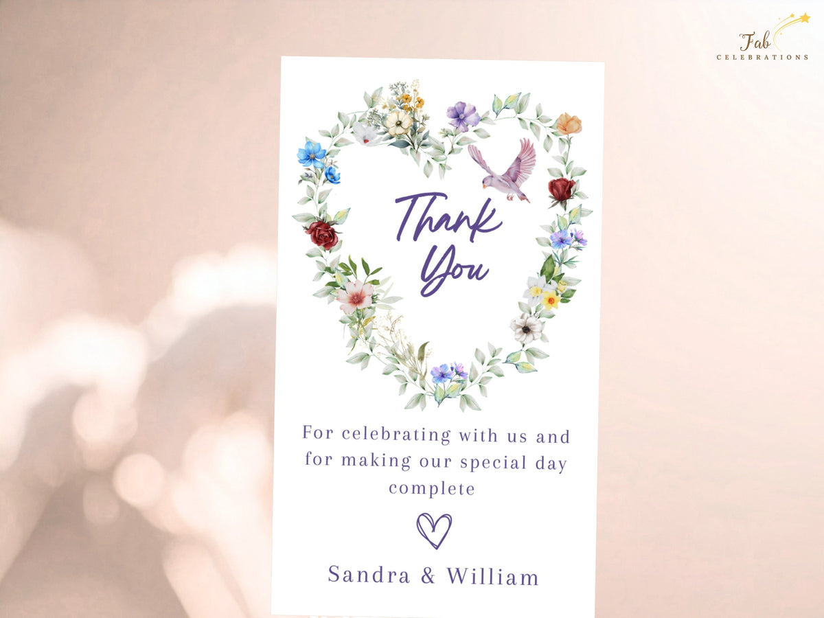 Floral gratitude card featuring a watercolor-inspired heart of multicolored blossoms and delicate greenery with a graceful dove above a heartfelt wedding thank you message from the couple.