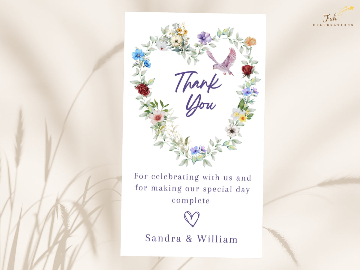 Floral wedding thank you card featuring a watercolor-inspired heart of colorful blossoms and leafy greenery with a graceful dove above a heartfelt gratitude message and the couple's names.