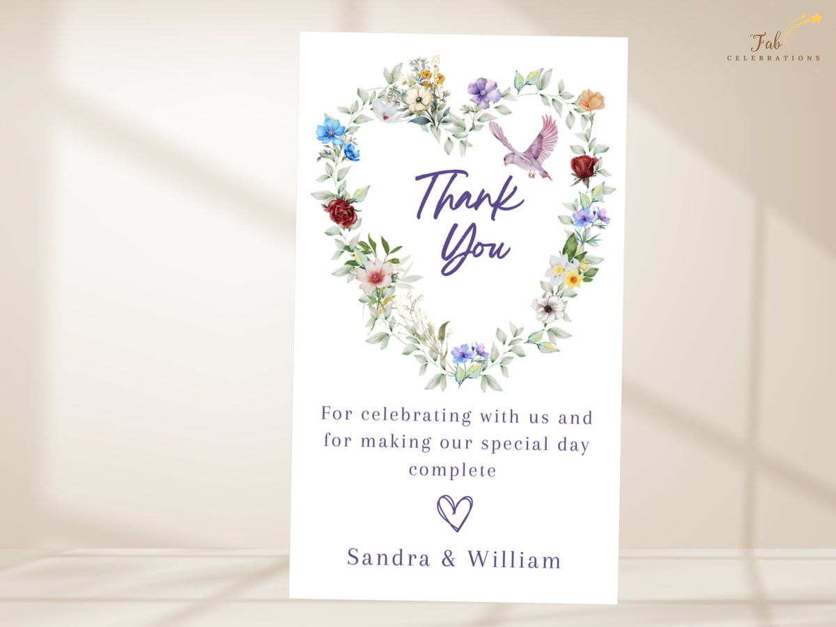 Garden wedding thank you card featuring a watercolor-inspired floral heart with colorful blossoms, leafy greenery and a graceful dove above a heartfelt thank you message and couple's names.