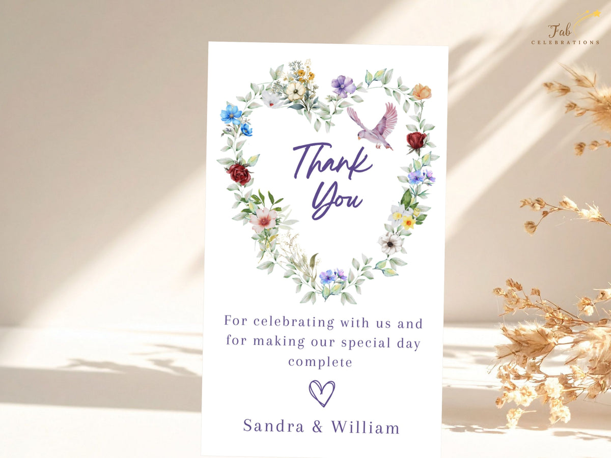 Romantic wedding thank you card featuring a watercolor-inspired floral heart of colorful blossoms and leafy greenery with a graceful dove above a heartfelt message and the couple's names.