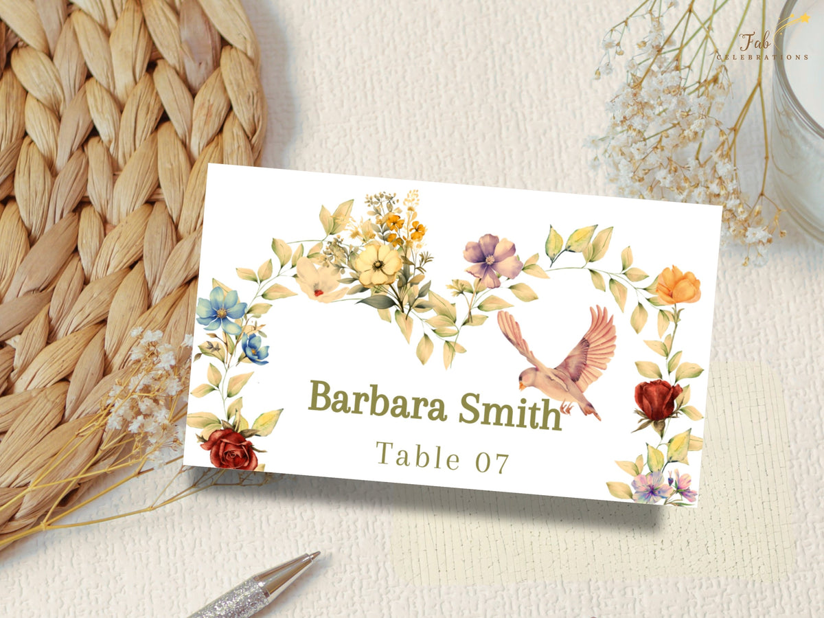 Close view of a romantic wedding name card with Barbara Smith and Table 07, surrounded by delicate watercolor-inspired yellow and pink blossoms, delicate leaves, and a dove on ivory.