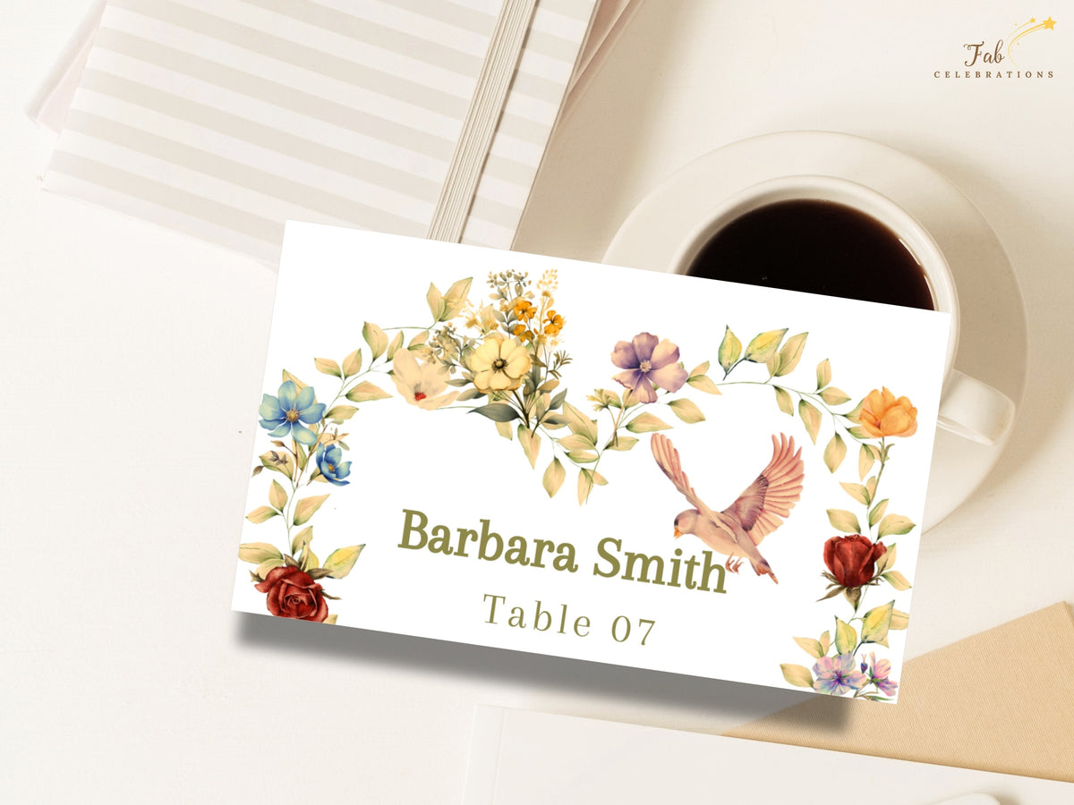 Romantic dove wedding name card shown beside a coffee cup, featuring Barbara Smith and Table 07 with delicate watercolor-inspired blush and golden blossoms and fine botanical greenery.