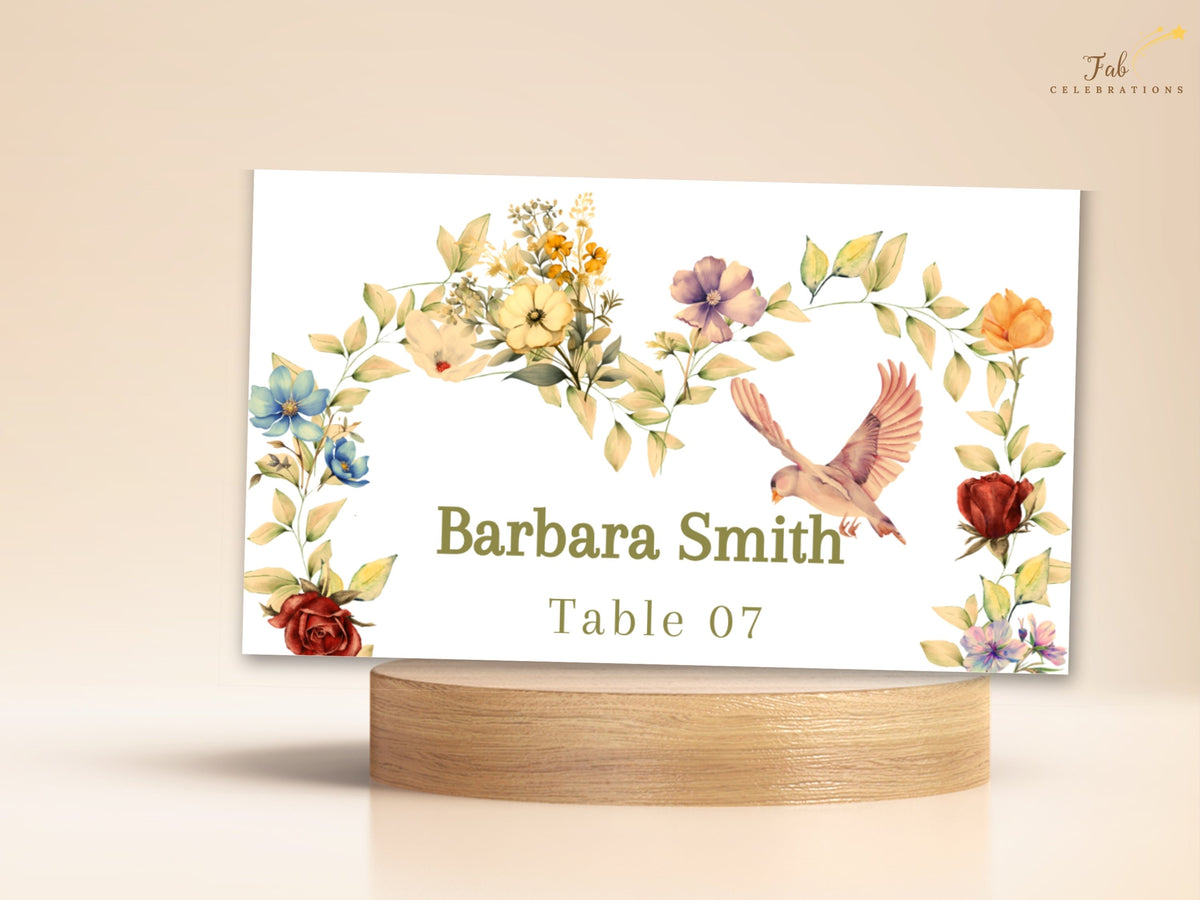 Romantic wedding name card featuring Barbara Smith and Table 07, framed by watercolor-inspired golden flowers, soft pink blossoms, sage greenery, and a graceful dove on an ivory place card.