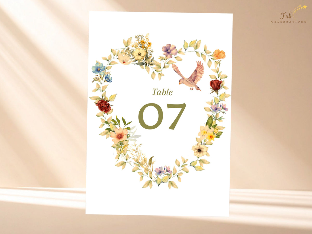 Romantic wedding table number featuring a watercolor-inspired heart wreath of pastel flowers and sage foliage, paired with two doves and a customizable olive green table number 07.