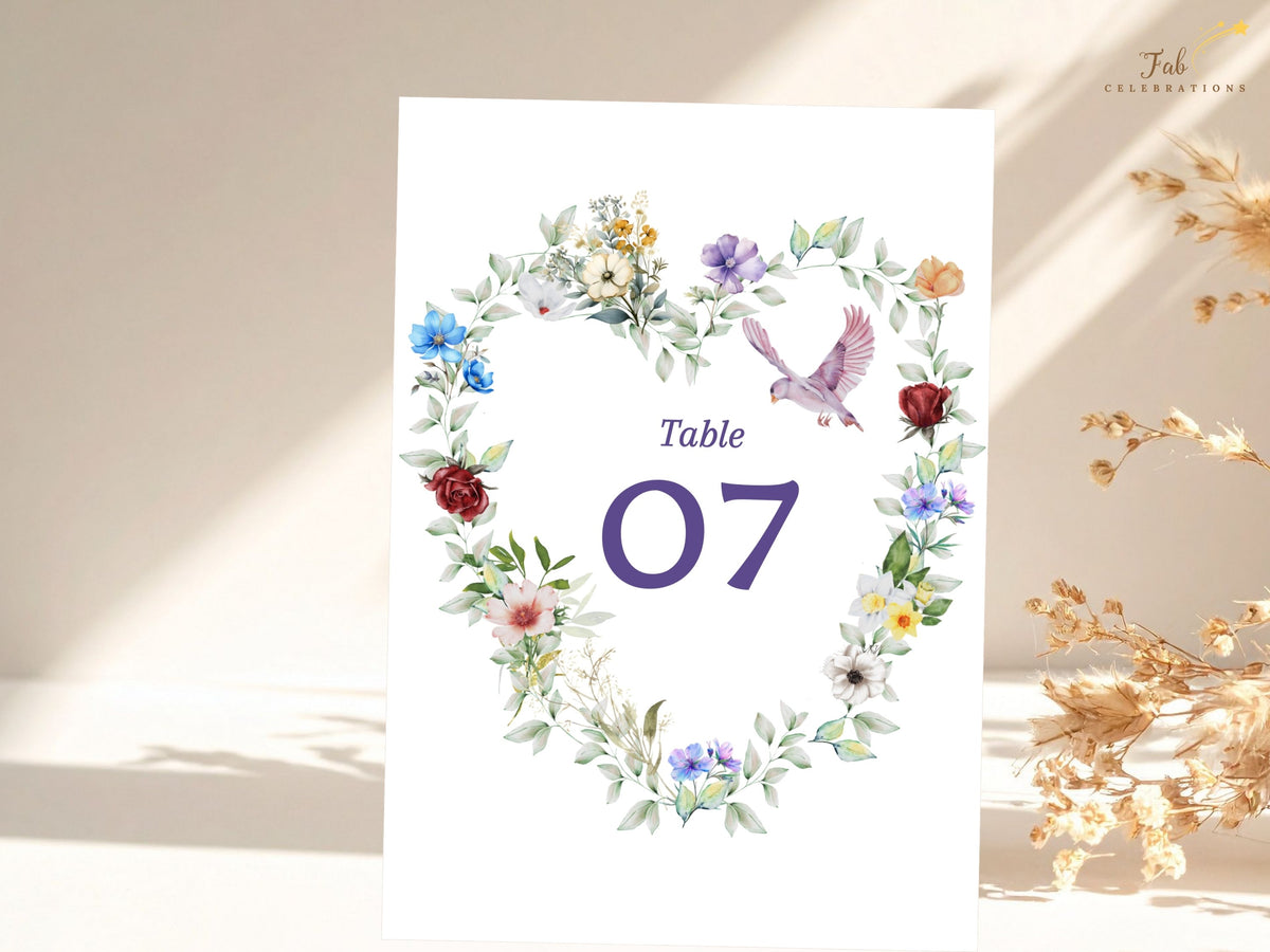 Elegant floral table number card featuring a watercolor-inspired heart of colorful garden blossoms and soft greenery with a graceful dove surrounding the reception table number 07.