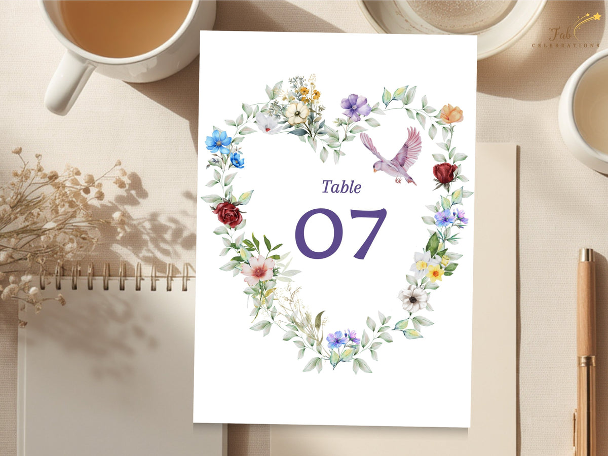 Wedding table number card featuring a watercolor-inspired floral heart of colorful blossoms and leafy greenery with a graceful dove surrounding the elegant reception table number 07.
