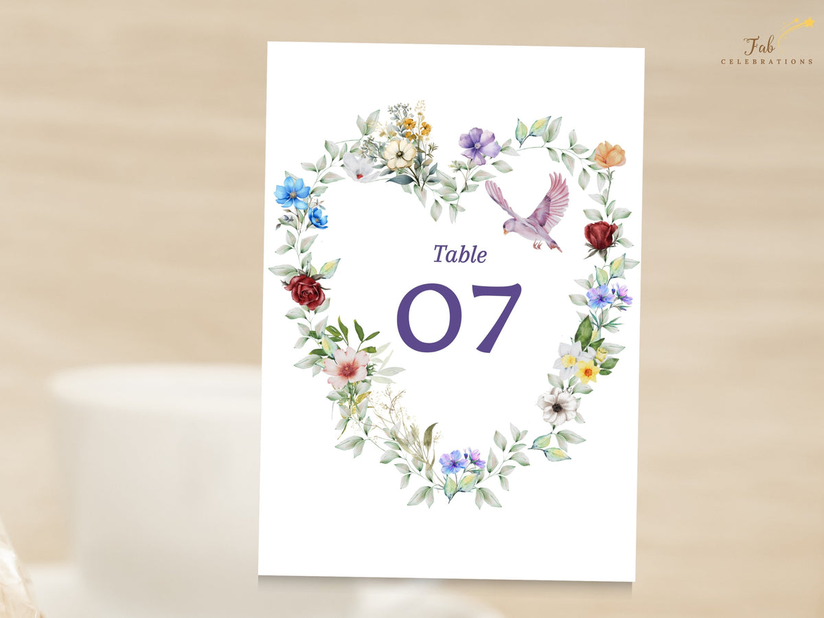 Watercolor-inspired wedding table number card featuring a romantic heart of colorful flowers and soft greenery with a graceful dove framing the elegant reception table number 07.
