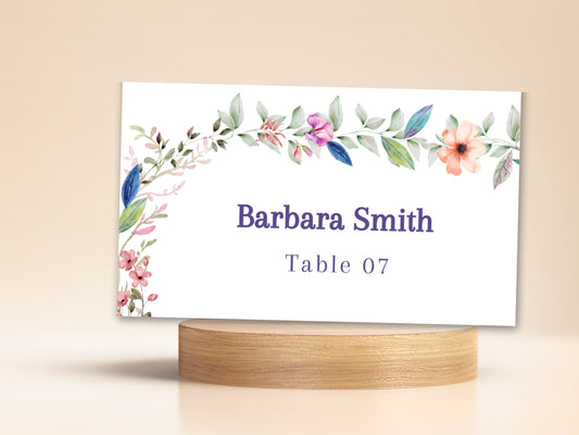 Wedding Place Card featuring delicate watercolor-inspired flowers and greenery around an editable guest name and table number for coordinated wedding reception seating.