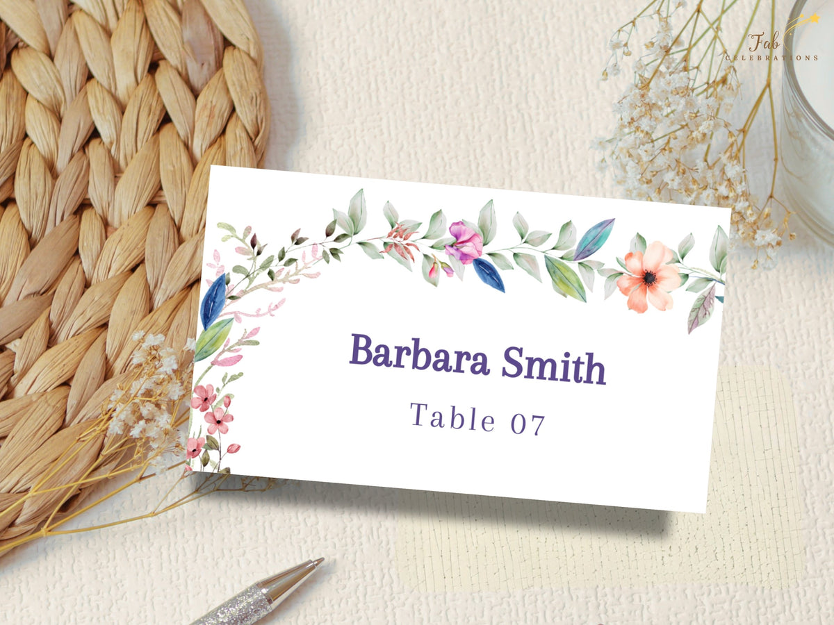 Floral wedding place card featuring watercolor-inspired botanical accents with a customizable guest name and table number for coordinated table settings.