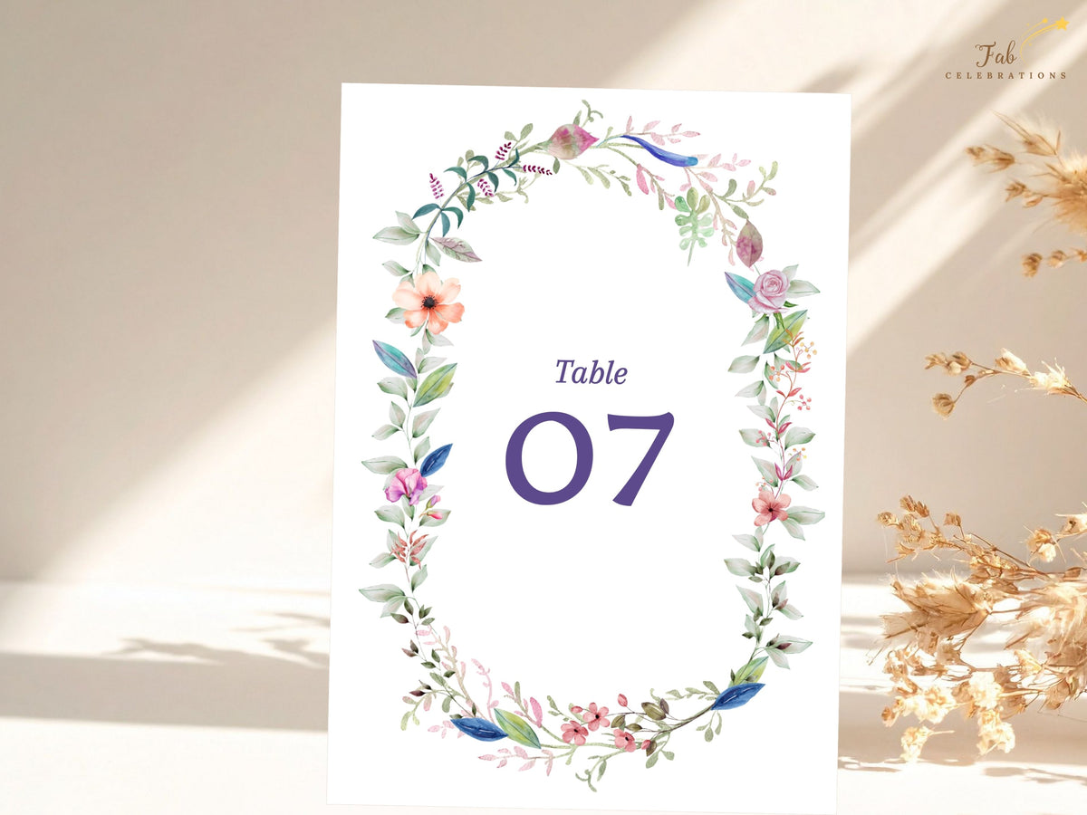 Printable Canva wedding table sign featuring a watercolor-inspired floral wreath with delicate blossoms, greenery, and customizable reception numbering.