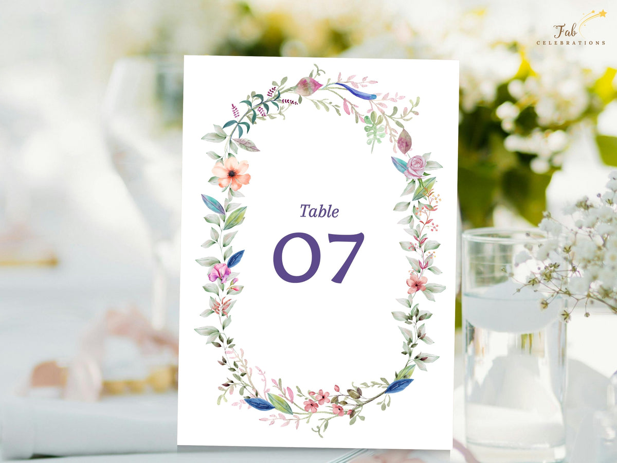 Floral wedding table number card featuring a watercolor-inspired botanical wreath with delicate blossoms, greenery, and elegant table numbering for a coordinated reception.