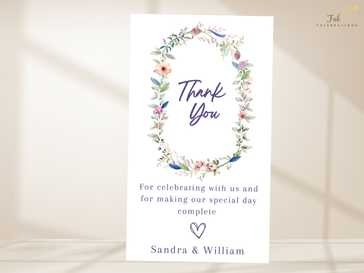 Wedding thank you note featuring a watercolor-inspired botanical wreath surrounding elegant thank you lettering, with customizable appreciation wording and names.